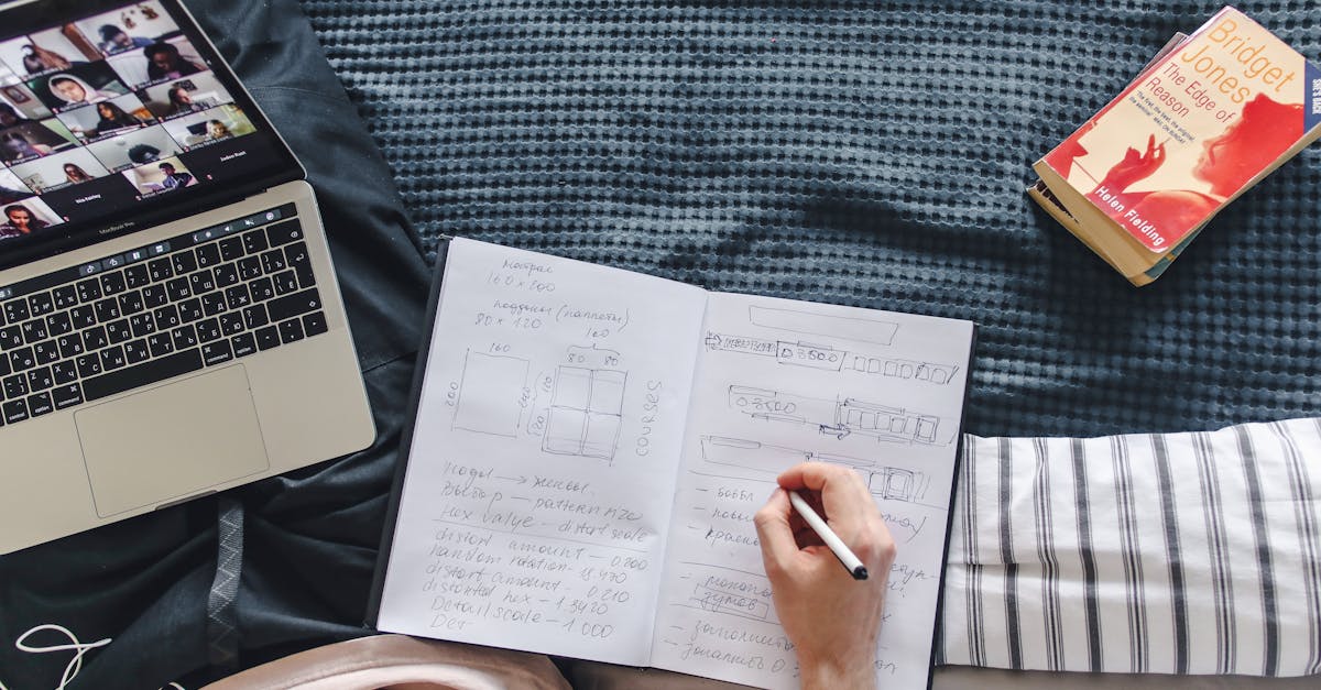 A tutor planning a private course outline with a notebook and laptop.